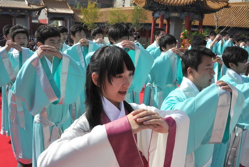 Students dressed with traditional Chinese clothes during Han Dynasty recite vows at a coming-of-age ceremony on the 2561st anniversary of Confucius&apos; birth at the Confucius Temple in Jinan, East China&apos;s Shandong province, Sept 28, 2010. [Xinhua]