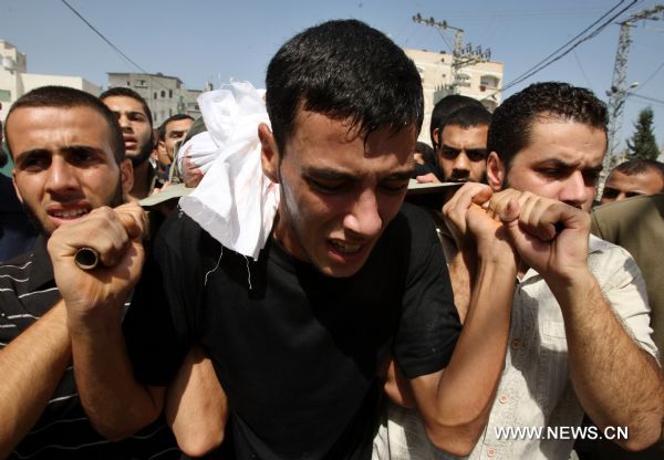 Palestinian mourners carry the body of Islamic Jihad militant Awni Abdelhadi, who was killed by Israeli shelling, during his funeral in the al-Bureij refugee camp, central Gaza Strip, Sept. 28, 2010. Three Palestinian militants from Islamic Jihad movement were killed on Monday night after they were targeted by an Israeli air-to-ground missile in central Gaza Strip, medics and witnesses said. [Xinhua]