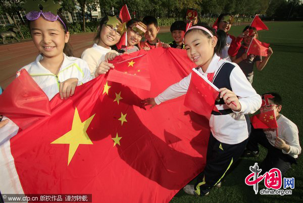 Students from Tianjin International School wave Chinese flags during the &apos;I Love You, China&apos; day as the 61st anniversary of National Day approaches. [CFP]