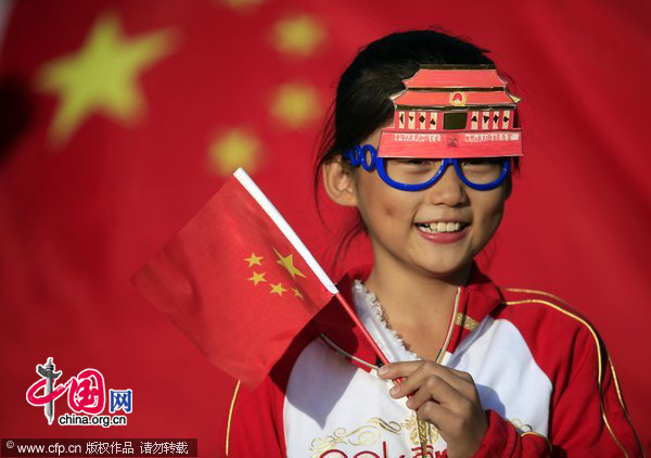 A girl with a specially-designed Tian&apos;anmen glass-ornaments poses for a photo during the &apos;I Love You, China&apos; for the 61 anniversary of National Day. [CFP]