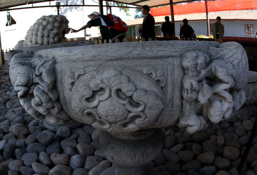 Visitors enjoy the sight of the returned cultural relics at Beijing's Yuanmingyuan, or the Old Summer Palace, on Monday, Sept 27. [Photo: Xinhua]