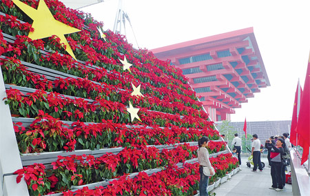 Visitors at the Expo Park pose Wednesday along the Expo Axis in front of a display of flowers arranged in the shape of a Chinese flag ahead of National Day Friday. Photo: Ni Dandan