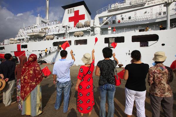 People wave Chinese national flags in front of China's hospital ship Peace Ark at the port of Djibouti, Sept. 29, 2010. The Peace Ark left for Kenya on Wednesday after providing medical services for local residents in Djibouti for a week. [Xinhua photo]