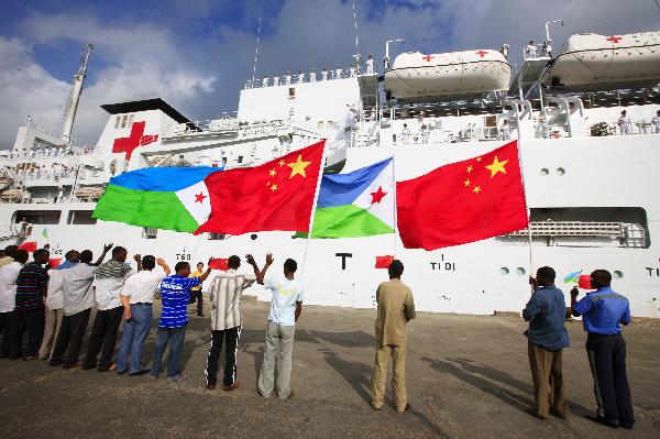 People wave national flags of China and Djibouti in front of China's hospital ship Peace Ark at the port of Djibouti, Sept. 29, 2010. The Peace Ark left for Kenya on Wednesday after providing medical services for local residents in Djibouti for a week. [Xinhua photo]