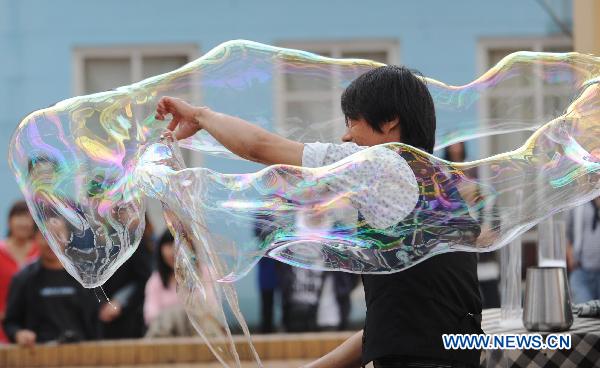 South Korean artist Lee Won-Jae gives soap bubble performance for visitors in an amusement park named 'the Window of the World' in Changsha, capital of central China's Hunan Province, Sept. 29, 2010.