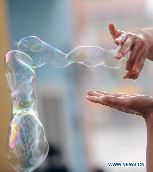 South Korean artist Lee Won-Jae gives soap bubble performance for visitors in an amusement park named 'the Window of the World' in Changsha, capital of central China's Hunan Province, Sept. 29, 2010.