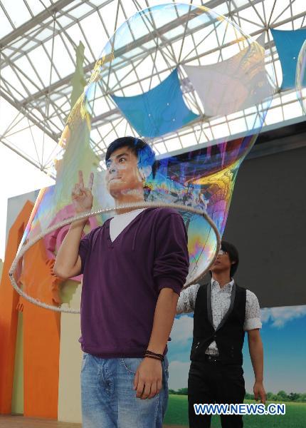 South Korean artist Lee Won-Jae (Rear) gives soap bubble performance for visitors in an amusement park named 'the Window of the World' in Changsha, capital of central China's Hunan Province, Sept. 29, 2010.