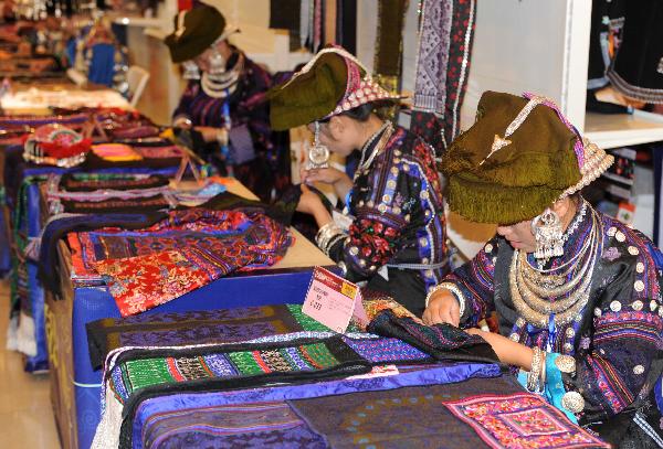 Folk artists make embroidery art works during a tourism products designing contest held in Guiyang, capital of southwest China's Guizhou Province, Sept. 29, 2010. Some 300 folk artists took part in the two-day contest, presenting more than 600 art works. [Xinhua photo]