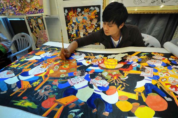 A man makes a painting during a tourism products designing contest held in Guiyang, capital of southwest China's Guizhou Province, Sept. 29, 2010. Some 300 folk artists took part in the two-day contest, presenting more than 600 art works. [Xinhua photo]