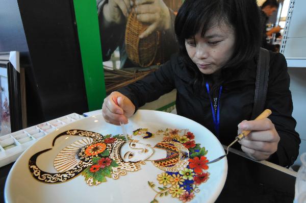 A woman makes an art work during a tourism products designing contest held in Guiyang, capital of southwest China's Guizhou Province, Sept. 29, 2010. Some 300 folk artists took part in the two-day contest, presenting more than 600 art works. [Xinhua photo]