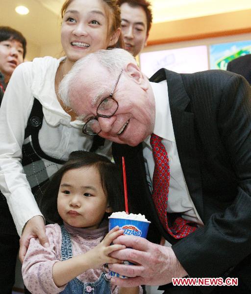 U.S. billionaire investor and Berkshire Hathaway CEO Warren Buffett (R) poses for a photo with a little customer while holding a cup of DQ ice cream at a new Dairy Queen store in Beijing, capital of China, Sept. 30, 2010.(Xinhua/Ren Zhenglai) 