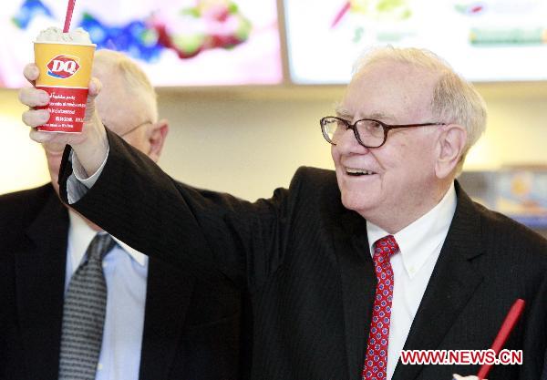 U.S. billionaire investor and Berkshire Hathaway CEO Warren Buffett (R) shows a cup of DQ ice cream at a new Dairy Queen store in Beijing, capital of China, Sept. 30, 2010.(Xinhua/Ren Zhenglai) 