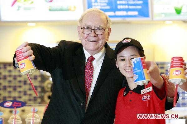 U.S. Billionaire investor and Berkshire Hathaway CEO Warren Buffett (L) and a staff member pose for a photo while each holding a cup of DQ ice cream upside down at a new Dairy Queen store in Beijing, capital of China, Sept. 30, 2010.(Xinhua/Ren Zhenglai)
