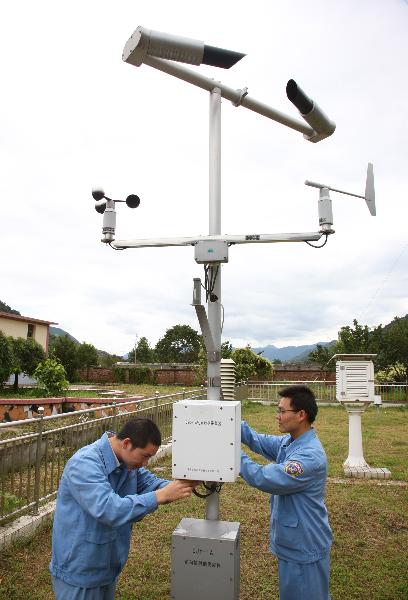 Photo taken on Sept. 29, 2010 shows scientists examine an automatic meteorological station in Xichang Satellite Launch Center in Xichang, southwest China's Sichuan Province.