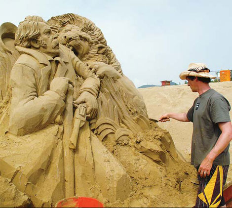 An artist puts the final touches to his sculpture. Provided to China Daily Island plays temporary home to exquisite beach art, Tang Zhihao reports.