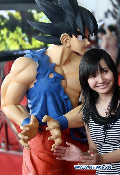 A girl poses with a model of a cartoon character produced by a local studio at n comic and animation exhibition in Dongguan, south China&apos;s Guangdong Province, Oct. 4, 2010. [Chen Fan/Xinhua]