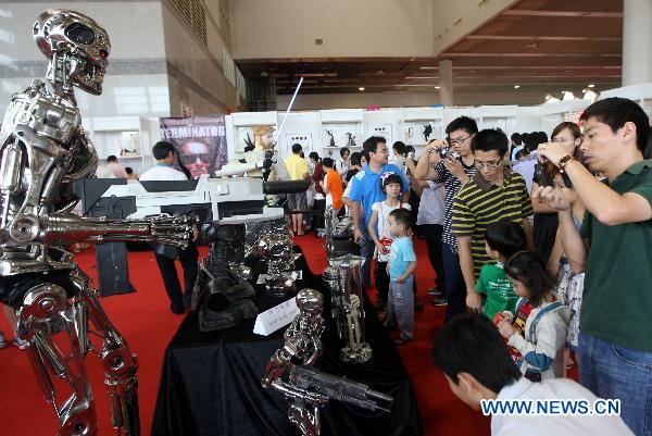 Visitors watch models of Hollywood movie characters produced by a local studio at a comic and animation exhibition in Dongguan, south China&apos;s Guangdong Province, Oct. 4, 2010. [Chen Fan/Xinhua]