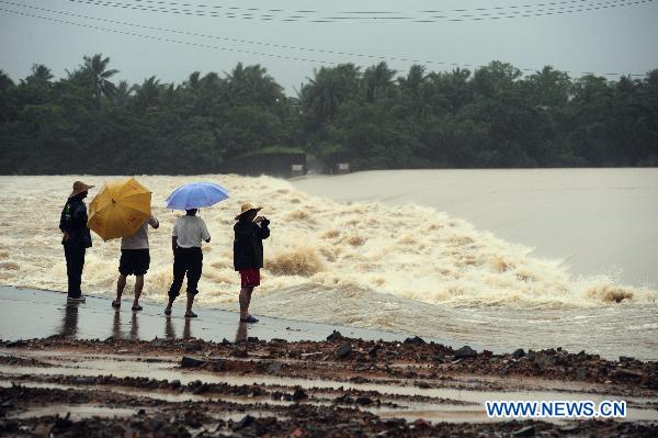 Citizens watch the flood water near the Wanquan River in Qionghai City, south China&apos;s Hainan Province, Oct. 5, 2010. Heavy rains will hit Leizhou Peninsula and Hainan Province where heavy rain has pounded for four days and the average precipitation has exceeded 200 mm in most parts, according to the local weather bureau. Local government and the weather bureau also issued warnings on potential geological disasters triggered by the heavy rains in seven cities and counties in Hainan. [Meng Zhongde/Xinhua]