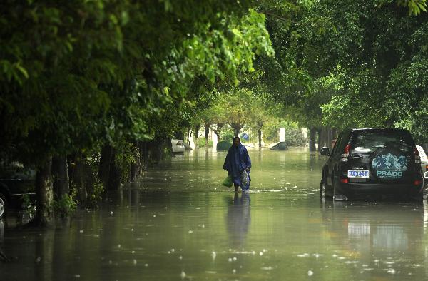 A man walks on a waterlogged street in Sanya, south China's Hainan Province, Oct. 5, 2010. Heavy rains will hit Leizhou Peninsula and Hainan Province where heavy rain has pounded for four days and the average precipitation has exceeded 200 mm in most parts, according to the local weather bureau. [Xinhua/Xu Qintao]