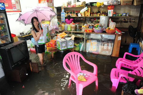 A shop owner transfer goods from the waterlogged shop in Qionghai, south China's Hainan Province, Oct. 5, 2010. Heavy rains will hit Leizhou Peninsula and Hainan Province where heavy rain has pounded for four days and the average precipitation has exceeded 200 mm in most parts, according to the local weather bureau. [Xinhua/Meng Zhongde]