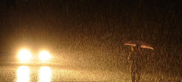 A person is seen walking in rain with an umbrella in Sanya, south China's Hainan Province, Oct. 4, 2010. Heavy rains will hit Leizhou Peninsula and Hainan Province where heavy rain has pounded for four days and the average precipitation has exceeded 200 mm in most parts, according to the local weather bureau. [Xinhua/Xu Qintao]