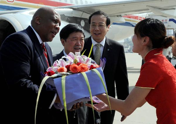 Lesotho's King Letsie III (L) receives flowers in Xi'an Xianyang International Airport near Xi'an, capital of northwest China's Shaanxi Province, Oct. 5, 2010. Letsie III arrived in Xi'an for a visit Tuesday. [Xinhua/Liu Xiao]