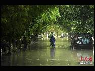 A man walks on a waterlogged street in Sanya, south China's Hainan Province, Oct. 5, 2010. Heavy rains will hit Leizhou Peninsula and Hainan Province where heavy rain has pounded for four days and the average precipitation has exceeded 200 mm in most parts, according to the local weather bureau. [Chinanews.com]