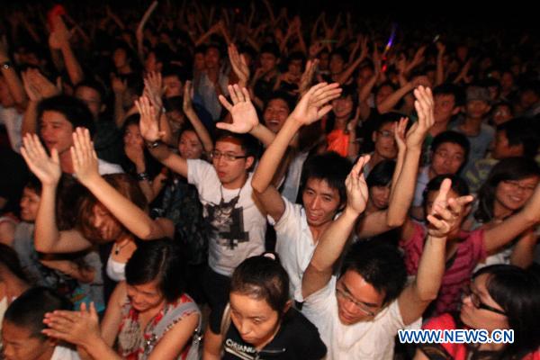 Audiences wave their hands during a beach music party in Zhuhai, south China's Guangdong Province, Oct. 4, 2010. [Xinhua/Li Jianshu] 