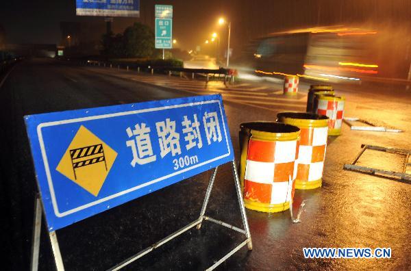 Photo taken on Oct. 5, 2010 shows a sign reading road closed in rain in Qionghai, south China's Hainan Province. Highways in east part of Hainan have been interrupted on Tuesday due to continuous heavy rains pouring over the province. [Xinhua/Guo Cheng]