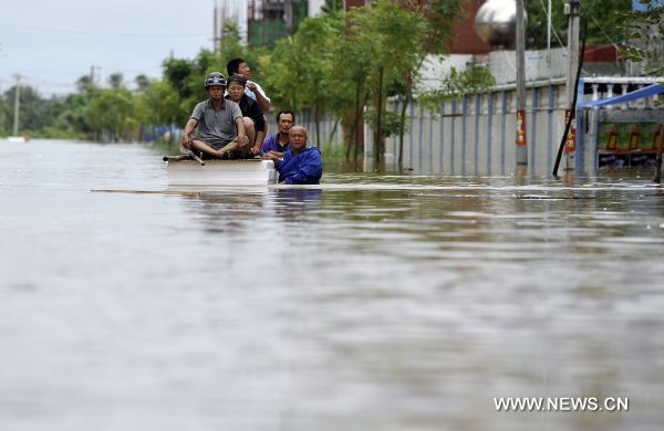 Residents make their way forward in a street submerged by floods in Qionghai, south China's Hainan Province, Oct. 6, 2010. Continuous heavy rains poured over Hainan, causing Qionghai waterlogged while over 10,000 residents had been transferred to safe areas. [Xinhua/Guo Cheng] 