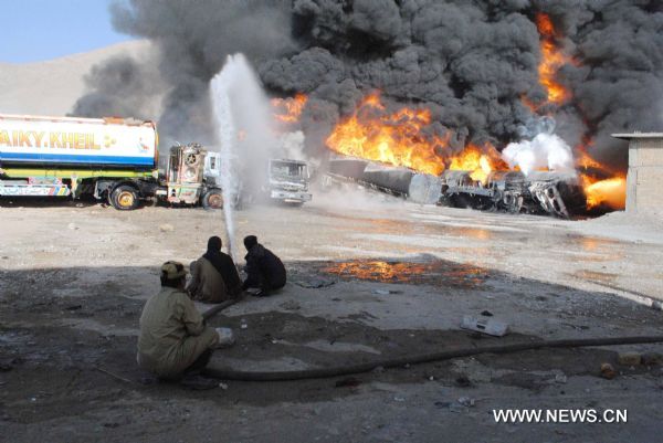 Firefighters try to put out the fire of NATO oil tankers burnt near Pakistan's southwest city of Quetta on October 6, 2010. At least one driver was killed as some twenty NATO oil tankers were attacked by unknown gunmen early Wednesday morning near Quetta, the fourth such attack in the country since last Friday. [Xinhua/Iqbal Hussain]