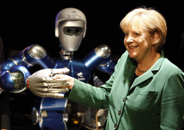 German Chancellor Angela Merkel poses for the media with a robot called 'Justin' at the ILA International Air Show in Schoenefeld south of Berlin, June 8, 2010.(Xinhua/Reuters Photo)