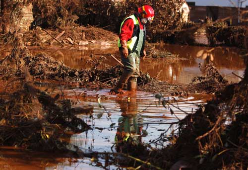 A rescue worker walks in toxic sludge in the flooded village of Kolontar, 150 km (93 miles) west of Budapest Oct 7, 2010. [China Daily/Agencies] 