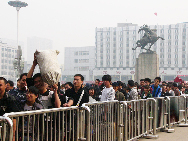 Passengers wait in lines to get into Handan railway station in North China's Hebei province, Oct 7, 2010. [Xinhua]