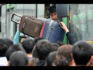 Passengers loaded with luggage rush to get on a bus in Hefei in East China's Anhui province, Oct 7, 2010. [Xinhua]