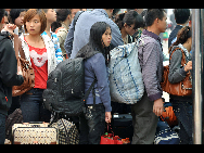 Passengers wait in lines to get on a bus in Hefei in East China's Anhui province, Oct 7, 2010.  [Xinhua] 