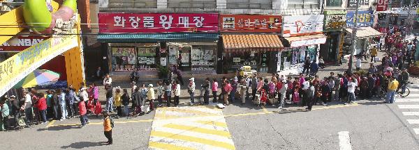 People stand in queues as they wait for their turn to buy cabbages subsidized by the Seoul city hall office, at a market in Seoul October 5, 2010. The price of local cabbage and other vegetables surged after heavy rainfall in the country. Autumn is the time for &apos;Kimchi&apos;, a traditional Korean event when kimchi -- the spicy pickled cabbage is prepared for the coldest months of winter. [Xinhua/Reuters]