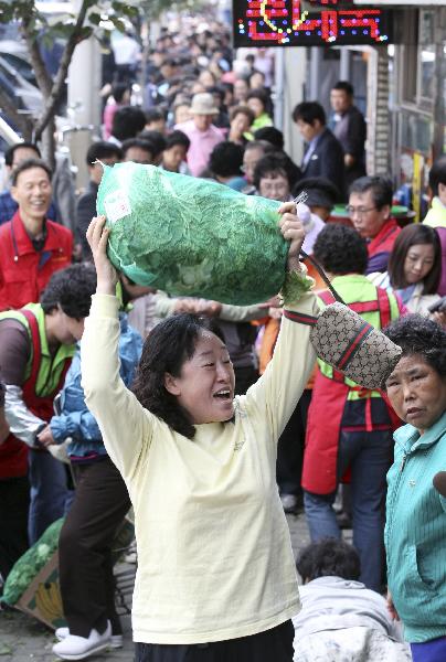 People stand in queues as they wait for their turn to buy cabbages subsidized by the Seoul city hall office, at a market in Seoul October 5, 2010. [Xinhua/Reuters]