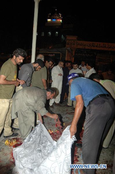 Rescuers work at a blast site at a shrine in Pakistan's southern port city of Karachi, Oct. 7, 2010. At least 14 people were killed and 70 others injured in two suicide blasts that took place Thursday night at a shrine. [Toheed/Xinhua]