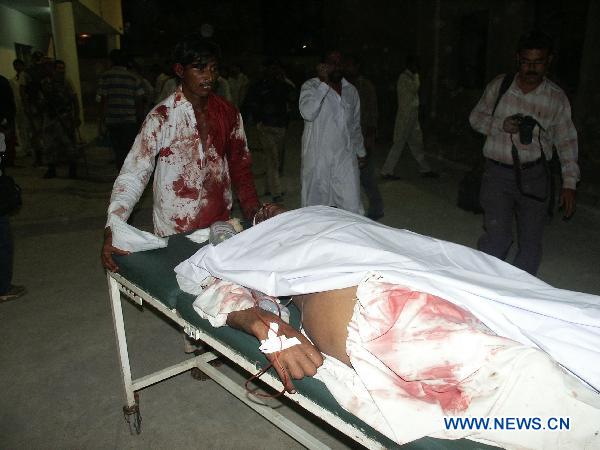 A man transfers a person injured in the blast at a shrine in Pakistan's southern port city of Karachi, Oct. 7, 2010. At least 14 people were killed and 70 others injured in two suicide blasts that took place Thursday night at a shrine. [Arshad/Xinhua]