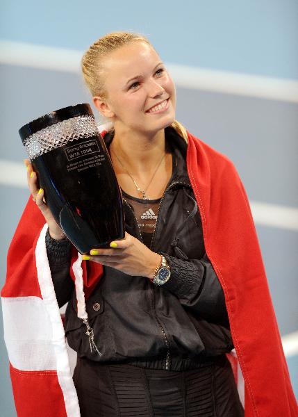 Caroline Wozniacki of Denmark celebrates becoming the new women's world number one player with the trophy after winning her women's singles third round match against Petra Kvitova of the Czech Republic at the China Open tennis tournament in Beijing, capital of China, Oct. 7, 2010. Wozniacki won 2-0. (Xinhua/Li Wen) 