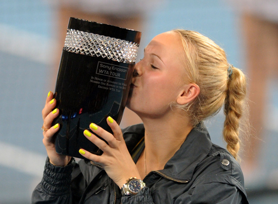 Caroline Wozniacki of Denmark celebrates becoming the new women's world number one player with the trophy after winning her women's singles third round match against Petra Kvitova of the Czech Republic at the China Open tennis tournament in Beijing, capital of China, Oct. 7, 2010. Wozniacki won 2-0. [Xinhua]