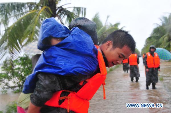  A soldier carries a child on his back in Haikou, capital of south China&apos;s Hainan Province, Oct. 7, 2010. 