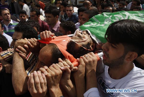 Palestinians carry the body of senior Hamas militant Nashad al-Karmi during his funeral in the West Bank city of Hebron, Oct. 8, 2010. [Xinhua] 