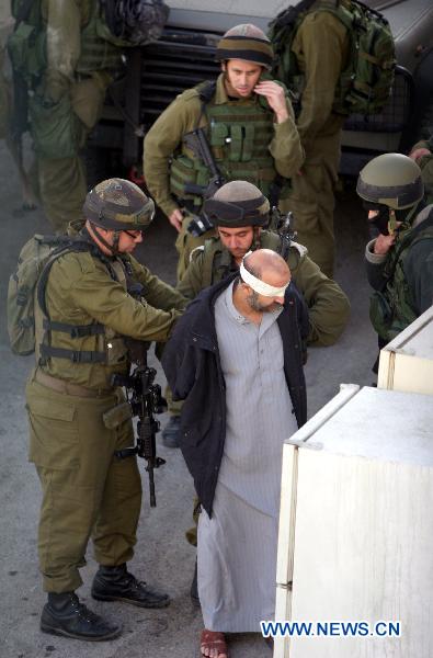 Israeli soldiers arrest a Palestinian man after a military raid in the West Bank city of Hebron, Oct. 8, 2010. [Xinhua] 