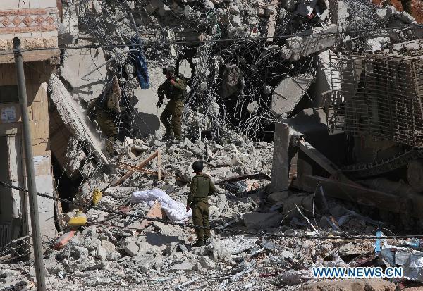 Israeli soldiers inspect a demolished house after a military raid in the West Bank city of Hebron, Oct. 8, 2010.[Xinhua] 