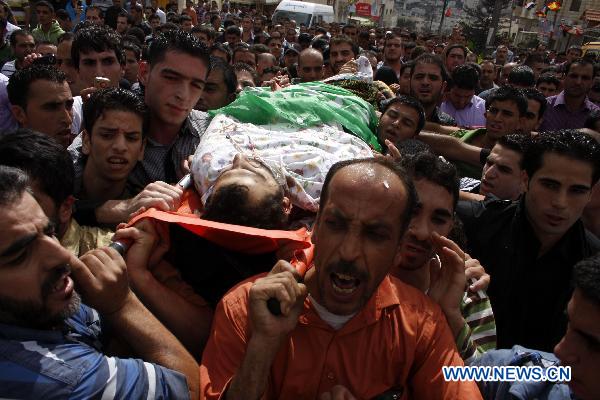 Palestinians carry the body of senior Hamas militant Nashad al-Karmi during his funeral in the West Bank city of Hebron, Oct. 8, 2010. [Xinhua] 