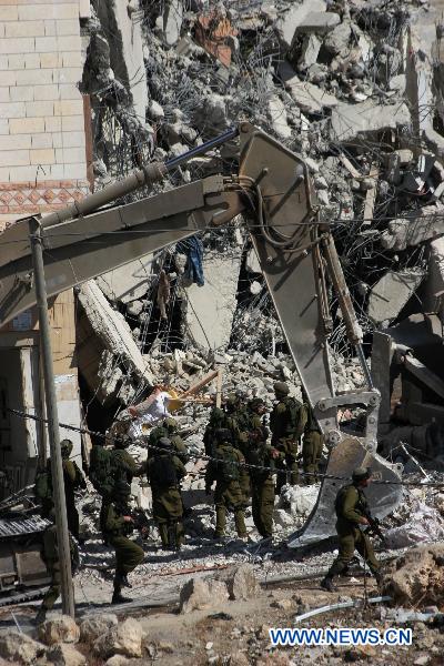 Israeli soldiers inspect a demolished house after a military raid in the West Bank city of Hebron, Oct. 8, 2010. [Xinhua] 