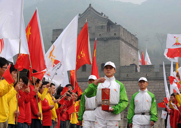 Guards protect the lantern with Asian Games flame and display it to the crowds at the Juyongguan Great Wall in Beijing on Saturday. [Xinhua]