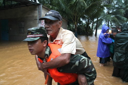 A soldier carries a woman in an emergency evacuation in Wenchang city, southern Hainan province, Friday, October 8, 2010. [Xinhua]